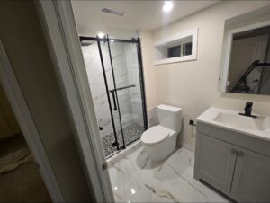Bathroom Remodeling by Star Inspiration Home Renovation. New 3-piece bathroom addition featuring luxury 2x2 porcelain tiling on the floor and shower walls, a custom mosaic shower base, a high-end toilet, and a stylish vanity with pot-lights and an exhaust fan.