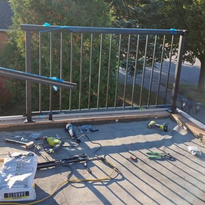 Work in progress showing a railing installation around the open balcony, enhancing safety for kids and family enjoyment.